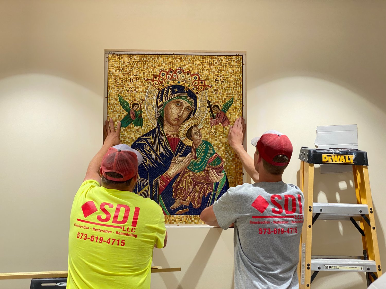 Construction workers install a mosaic of Mary under her title Our Lady of Perpetual Help behind the reception desk near the entrance to the Alphonse J. Schwartze Memorial Catholic Center in Jefferson City. For 53 years, the mosaic, created in Italy, adorned a side wall of the Cathedral of St. Joseph, which is undergoing a major renovation.